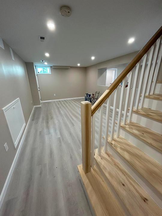 Basement renovation featuring new flooring and stair installation