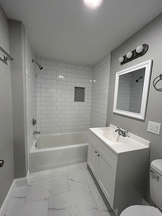 Bathroom remodel featuring new tub, tile walls, and updated fixtures
