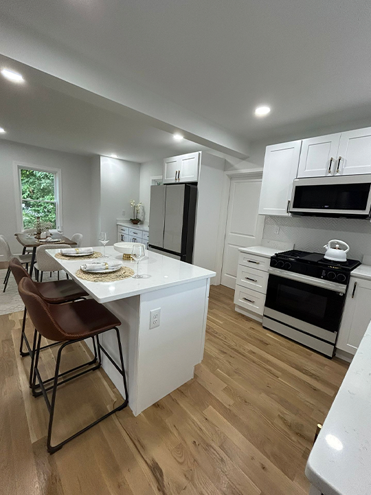 Modern white kitchen remodel with island and stainless steel appliances