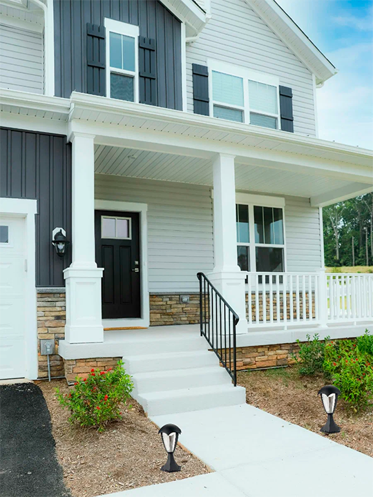 Home exterior with new white siding installation and front porch renovation
