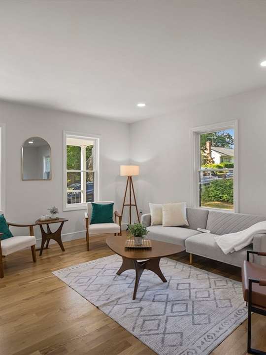 Fully renovated living room in flip house with modern finishes and natural lighting