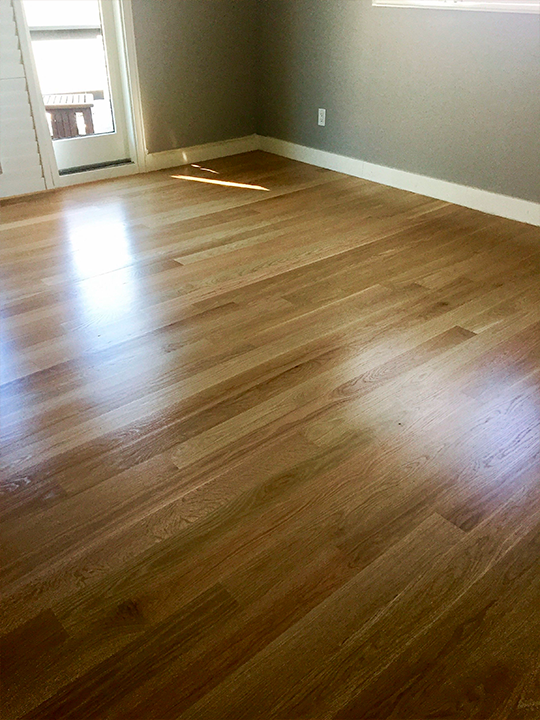 Newly installed light-tone wood flooring in home interior